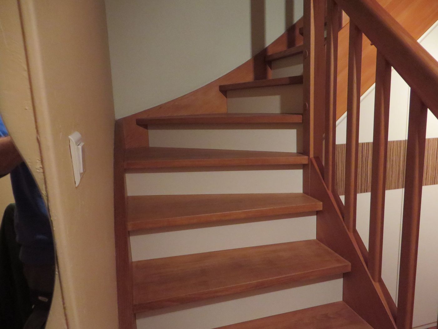 Escalier quart tournant en bois teinté brun-rouge, contremarches blanches, rampe et balustres bois